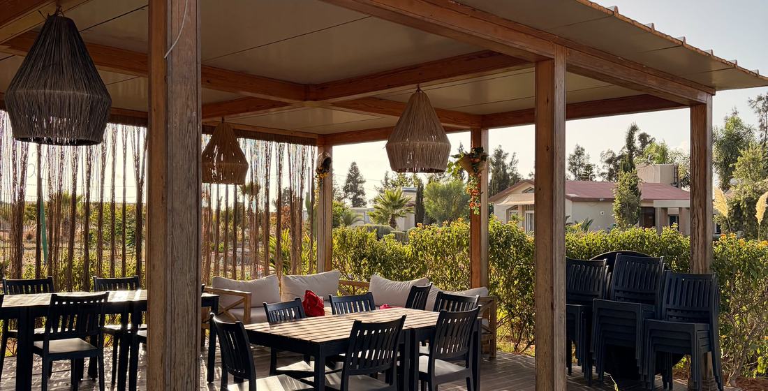 Pergola en bois avec tables et suspensions en fibre naturelle, ouverte sur le jardin